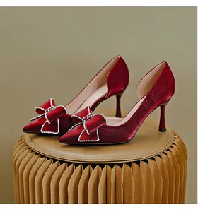 Eleganti tacchi a spillo in raso rosso vino con fiocco di strass scintillanti sulla punta.
