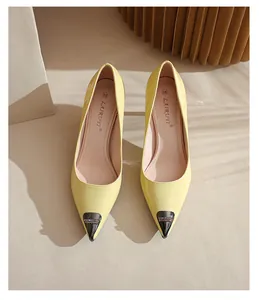 Detailed top view of yellow pointed-toe patent leather pumps with rhinestone metal toe