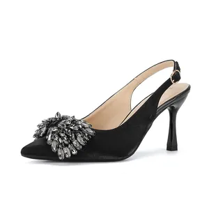 Side view of elegant black pointed-toe stiletto heels with rhinestone burst detail