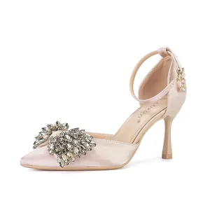 Pointed toe stiletto pumps with champagne satin finish and elegant crystal bow detail