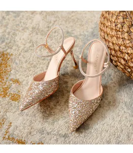 Detailed view of champagne gold glitter pointed-toe pumps with rhinestone straps.