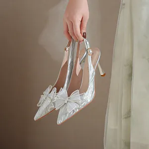 Tacones de punta plateados con purpurina, lazo de cristal y diseño de aguja slingback