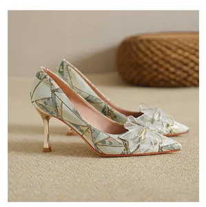 Side view of elegant French stiletto pumps with geometric pattern and mesh bow detail.