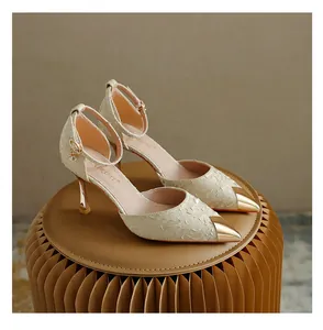 Close-up of elegant pointed-toe high heels with gold metallic cap and ankle strap