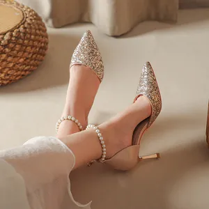 Elegant champagne pointed-toe stiletto pumps with glitter finish and pearl anklet strap.