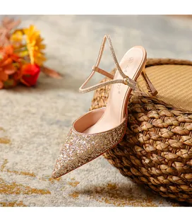 Detailed view of elegant gold glitter pointed-toe high heels with rhinestone straps