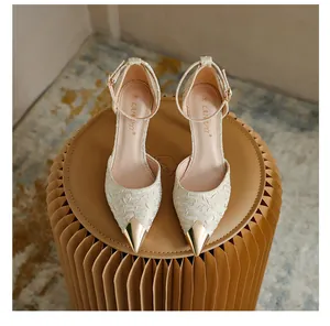 Detailed view of champagne satin pointed toe heels with elegant metallic gold cap