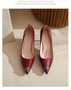 Close-up of red patent leather pointed-toe heels with metallic crystal-studded cap