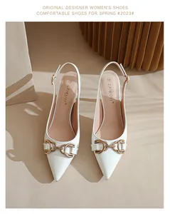 Vue de dessus d'élégants talons hauts blancs en cuir verni avec boucle mors dorée