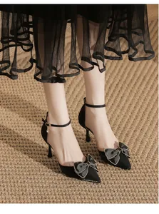 Elegante schwarze spitze Pumps mit feiner Schleife und schmalem Knöchelriemen-Detail.