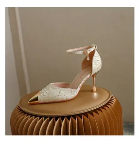 Detail of elegant pointed toe heels with metallic cap and crystal ankle strap charm.