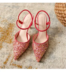 Close-up detail of elegant red glitter pointed-toe stiletto heels with rhinestone straps