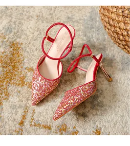 Close-up of red glitter pointed-toe high heels with rhinestone ankle straps