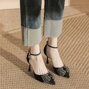 Elegant black pointed-toe high heels featuring crystal bow and ankle strap for women