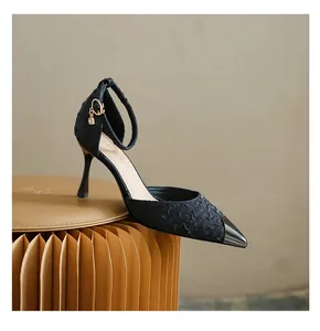 Detail of black pointed-toe high heel pump with metallic toe cap and ankle strap.