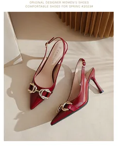 Détail d'escarpins slingback en cuir verni rouge avec boucle mors dorée