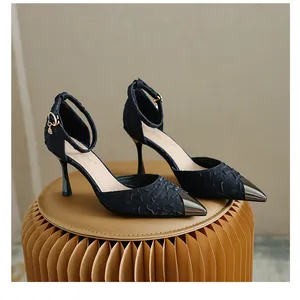 Macro view of black satin high heels featuring a metallic toe cap and ankle strap