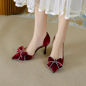 Eleganti scarpe décolleté in raso bordeaux a punta con un lussuoso fiocco in strass.