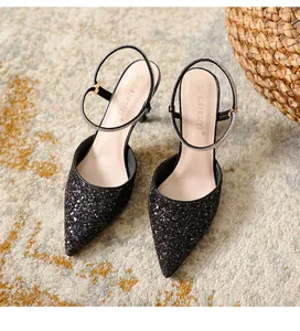 Close-up of elegant black glitter pointed-toe stiletto heels with shimmering rhinestones
