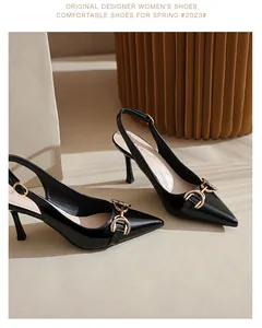 Détail d'escarpins slingback en cuir verni noir avec boucle mors dorée élégante