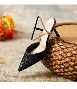 Detail of elegant black glitter pointed-toe high heels with sparkling rhinestone strap