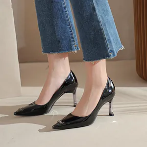 Stylish black patent leather pointed toe high heel pumps for women in casual jeans.