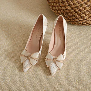 Elegant French style pointed toe stiletto pumps with large decorative bow and gold patterns