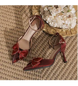 Detailansicht von weinroten Stilettos mit spitzer Zehenpartie, Schleife und Knöchelriemen