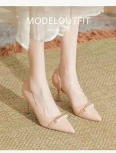 Detail of pointed toe nude pumps with pearl chain strap and stiletto heels for work.