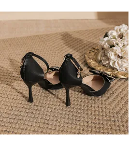 Rückansicht eleganter schwarzer Stiletto-Pumps mit dekorativer Schleife und Knöchelriemen