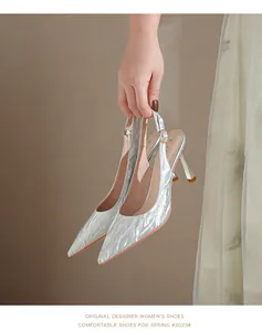 Handheld view of elegant silver zebra pattern pointed toe slingback high heel pumps