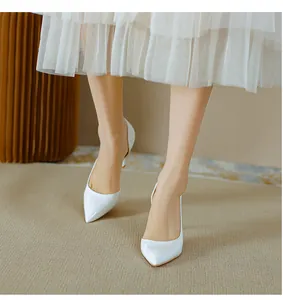 Élégants escarpins d'Orsay en cuir verni blanc avec bout pointu portés par un modèle