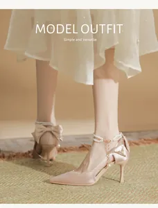 Detail view of champagne bridal high heels with elegant pearl ankle straps and bows