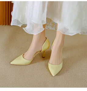 Détail d'élégants escarpins d'Orsay jaune pâle à bout pointu et talons aiguilles fins.