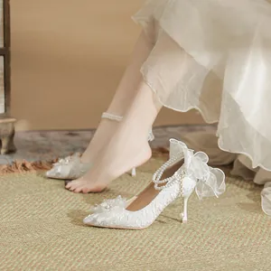 Elegant French style white bridal high heels featuring delicate lace bows and pearl straps