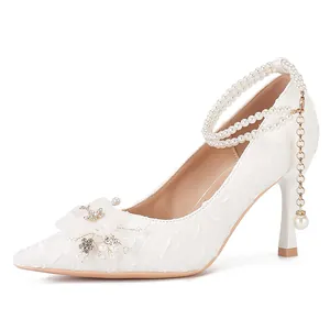 Elegantes tacones de aguja blancos estilo francés con tira de perlas y encaje floral.
