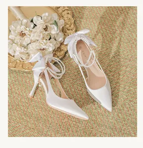 Elegant white satin wedding high heels featuring a pearl ankle strap and back bow detail