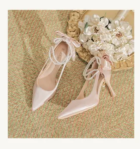 Elegant blush pink satin wedding high heels with pearl ankle straps and bows