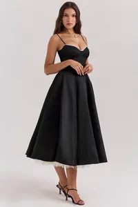 Detail van een elegante zwarte Franse midi-jurk met mesh inzetstukken en baleinen