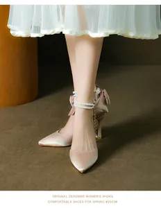 Elegant champagne satin pointed toe pumps with pearl ankle straps and bow detail