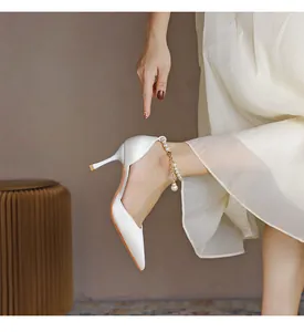 Elegante weiße spitze Stilettos mit einem zarten Knöchelriemen aus Perlenverzierung