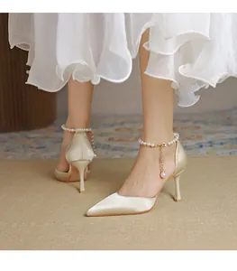 Elegante champagnerfarbene Satin-High-Heels mit dekorativen Perlen-Knöchelriemen