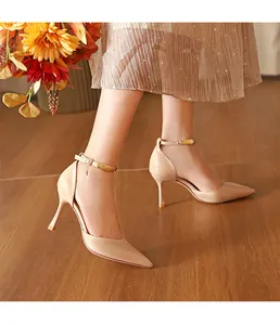 Elegante nudefarbene Stiletto-Pumps mit spitzer Zehenpartie und goldenem Riemen.