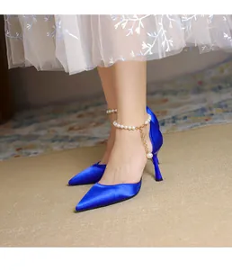 Detailansicht eleganter blauer Satin-Pumps mit spitzer Zehenpartie und Perlenknöchelriemen