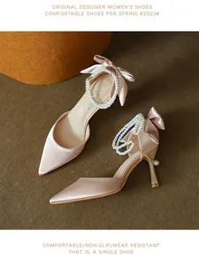 Elegant pink satin stiletto heels featuring a delicate bow and pearl ankle strap detail