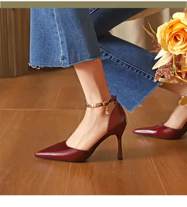 Seitenansicht-Detail weinroter Lackleder-Stilettos mit dekorativem Knöchelriemen-Anhänger