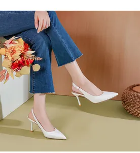 Κομψές λευκές γόβες slingback με μυτερή μύτη και λεπτό τακούνι φορεμένες από μοντέλο