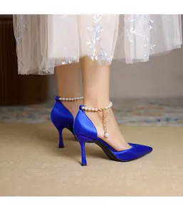 Elegante königsblaue Satin-High-Heels mit spitzer Zehenpartie und feinem Perlen-Fußkettchen.