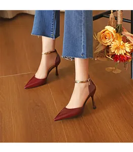 Nahaufnahme von weinroten Stiletto-Pumps mit spitzer Zehenpartie und Knöchelriemen