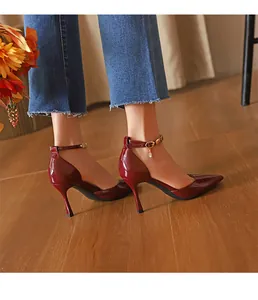 Nahaufnahme von eleganten weinroten Lackleder-Stilettos mit spitzer Zehenpartie.